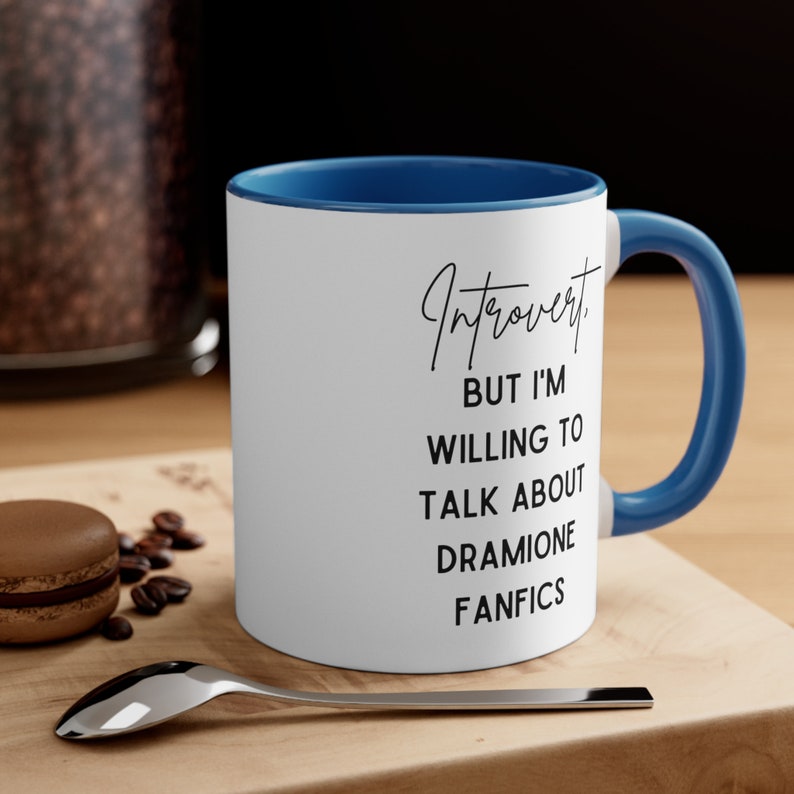 Puede incluir: Taza de cer&aacute;mica blanca con borde y asa azules. La taza tiene texto negro que dice "Introvertido. Pero estoy dispuesto a hablar sobre Fanfics de Dramione."