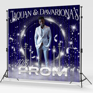 May include: A blue and silver prom backdrop with a man in a white suit standing in front of a silver circle. The backdrop has silver stars and confetti. The text "Jaquan & Davariona's 2023 Prom" is at the top of the backdrop.