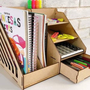 May include: A wooden desk organizer with multiple shelves and a drawer. The organizer has a light wood finish and is filled with various items, including books, pens, pencils, and a calculator. The text "Cuentos de Princesas" is visible on one of the books.