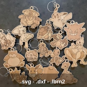 May include: A selection of wooden Pokémon character keyrings. Each keyring is laser-cut from light-coloured wood and includes a metal ring. The image includes characters such as Pikachu, Bulbasaur, and Gengar. The file types .svg, .dxf, and .lbrn2 are visible.