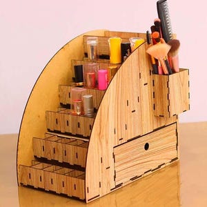Könnte beinhalten: Holzorganizer mit mehreren Fächern zur Aufbewahrung von Make-up-Pinseln, Lippenstiften und anderen Beauty-Produkten. Der Organizer hat eine Schublade und ein separates Fach für Pinsel.