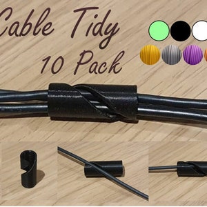 May include: A 10 pack of black cable tidies. The tidies are made of plastic and are designed to keep cables organized. The tidies are shown in different configurations, including a single tidy holding two cables, a single tidy holding one cable, and a single tidy holding three cables.