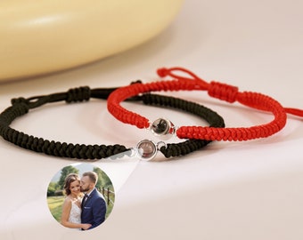 Puede incluir: Dos pulseras a juego con un cordón rojo y negro. Cada pulsera tiene un dije de plata con una cuenta de vidrio transparente que se puede personalizar con una foto.