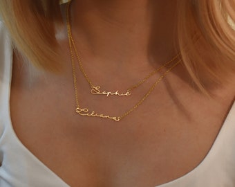 May include: Two gold necklaces with the names "Sophia" and "Liliana" written in cursive script.