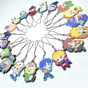 May include: A collection of colorful anime character charms with black lanyards. The charms feature various characters in vibrant colors, including red, blue, yellow, and green. Each charm is made of a rubbery material and has a detailed design.