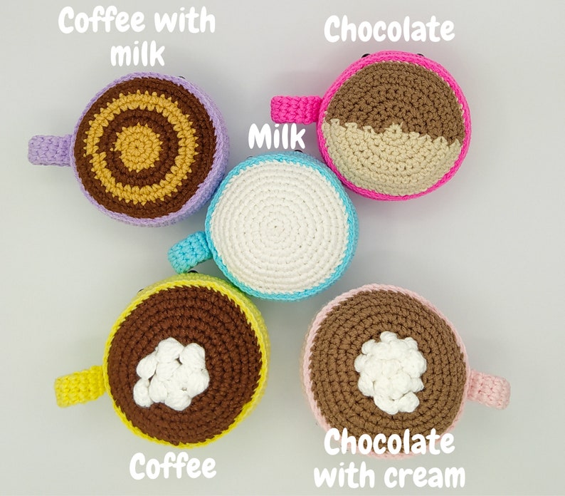 May include: Five crocheted coffee mugs in different colors and designs. The mugs are decorated with coffee, chocolate, milk, and cream. The mugs are labeled with the text "Coffee with milk", "Chocolate", "Milk", "Coffee", and "Chocolate with cream".