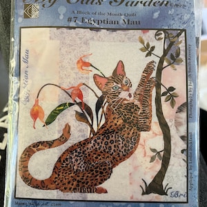 May include: A block of the month quilt pattern featuring an Egyptian Mau cat climbing a tree with flowers. The pattern is titled "My Cats Garden" and is numbered #7. The pattern is from Maggie Walker Design and includes the copyright year 1999.