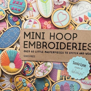 以下が含まれることがあります： Sonia Lyne著の書籍「Mini Hoop Embroideries: Over 60 Little Masterpieces to Stitch and Wear」。表紙には、花柄、幾何学模様、抽象的なデザインなど、小さな木製の刺繍枠に入った様々なカラフルな刺繍作品のコラージュが描かれています。