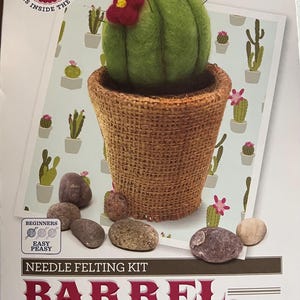 May include: Needle felting kit to make a barrel cactus. The kit includes everything you need to create a green and brown cactus with a red flower. The kit is labeled "Easy Peasy" and is from the Crafty Kit Co.