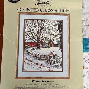 May include: Counted cross stitch pattern for a winter scene with a red house, snow-covered trees, and a mailbox. The finished size is 12 inches by 16 inches and the matted size is 16 inches by 20 inches. The pattern is designed by John Sloane and is part of the Something Special collection.
