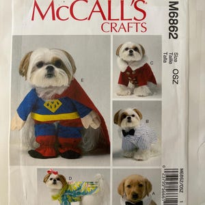 May include: McCall's Crafts M6862 sewing pattern envelope featuring five dog costume variations: a superhero outfit with cape, a red coat with white fur trim, a blue and white striped shirt with a bow tie, a floral print shirt, and a white collar with a bow tie.