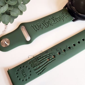 May include: Green silicone watch band with the text "We the People" and a design of the American flag with the text "1776" around it.