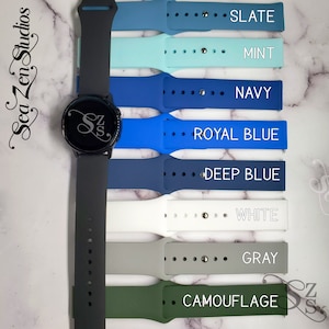 May include: A black smartwatch with a variety of colored silicone watch bands. The bands are labeled with the colors: Slate, Mint, Navy, Royal Blue, Deep Blue, White, Gray, and Camouflage.