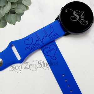 May include: Blue silicone watch band with a heart and stethoscope design. The band is engraved with the text "Nurse Life" and "Damaris".