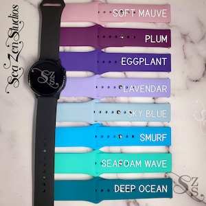 May include: A set of eight silicone watch bands in various colors, including soft mauve, plum, eggplant, lavender, sky blue, smurf, seafoam wave, and deep ocean. The bands are shown with a black smartwatch.