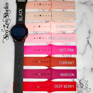 May include: A set of nine silicone watch bands in various shades of pink, red, and orange. The bands are labeled with the following colors: Black, Salmon, Blush, Carnation, Pink Lemonade, Hot Pink, Currant, Maroon, and Deep Berry.