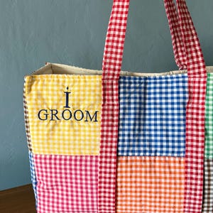 Puede incluir: Un bolso tote acolchado con un dise&ntilde;o de patchwork de cuadros vichy multicolores en amarillo, azul, rojo, naranja y verde. El bolso tiene asas de cuadros vichy rojos y blancos y el texto azul oscuro bordado I GROOM en el cuadrado amarillo.