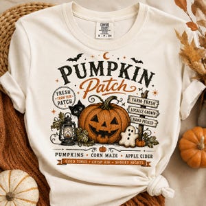 Pode incluir: Uma t-shirt cor de creme com uma impressão gráfica com o texto PUMPKIN PATCH, FRESH FROM OUR PATCH, FARM FRESH, LOCALLY GROWN, HAND PICKED, PUMPKINS, CORN MAZE, APPLE CIDER, GOOD TIMES, CRISP AIR e SPOOKY NIGHTS com uma abóbora.