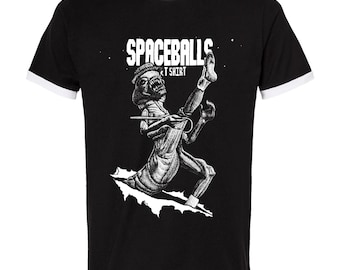 Könnte beinhalten: Schwarzes T-Shirt mit weißem Besatz. Das Shirt zeigt den Text "SPACEBALLS T SHIRT" über einer Schwarz-Weiß-Illustration einer Kreatur, die durch eine weiße Oberfläche bricht.