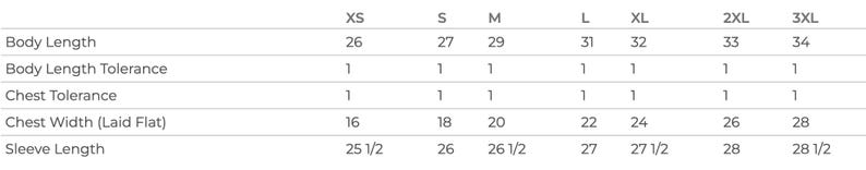 Op de afbeelding: Maattabel voor een kledingstuk met maten in inches voor lichaamslengte, lichaamslengtetolerantie, borsttolerantie, borstbreedte en mouwlengte. De maten omvatten XS, S, M, L, XL, 2XL en 3XL.