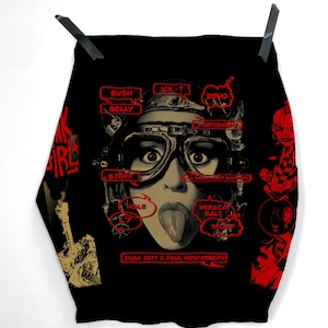 Peut inclure: Impression artistique graphique noire avec une femme portant des lunettes et tirant la langue, avec des bulles de texte rouges et les mots "JOAN JETT & PAUL WESTERBERG". L'impression comprend les noms "BUSH", "BELLY", "ICE-T", "DEVO", "BJORK", "HOLE", "VERUCA SALT", et "STOMP".