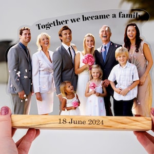 May include: A clear acrylic photo frame with a family photo of eight people. The photo shows a wedding party with the text "Together we became a family" at the top and the date "18 June 2024" at the bottom.