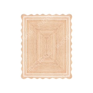 Op de afbeelding: Een rechthoekig jute vloerkleed met een geschulpte rand. Het vloerkleed heeft een natuurlijke beige kleur met een witte rand en een rechthoekig patroon in het midden. Het vloerkleed is ontworpen voor gebruik binnenshuis.