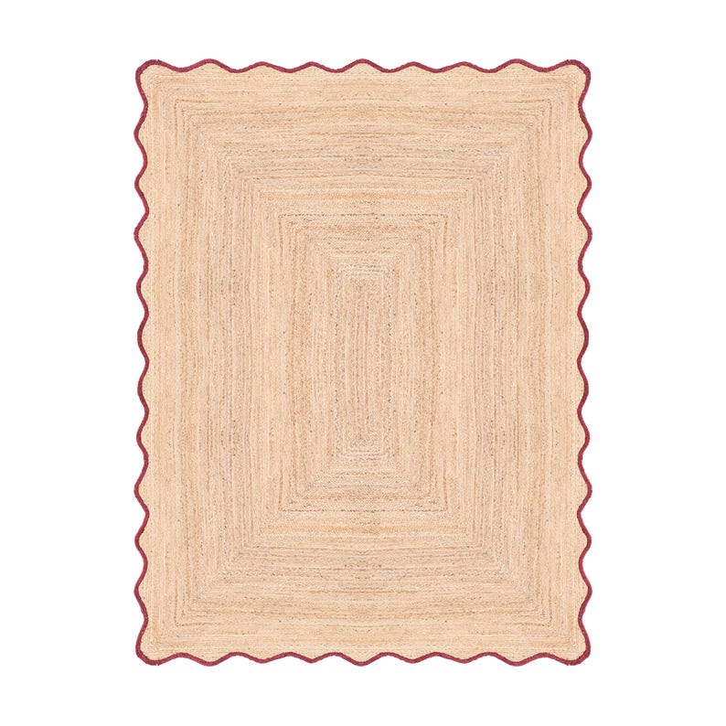 Puede incluir: Una alfombra rectangular hecha de fibras de yute tejidas en color tostado natural. La alfombra presenta un borde festoneado distintivo acabado con un borde fino y s&oacute;lido de color rojo oscuro que sigue el contorno ondulado del per&iacute;metro.