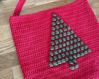 May include: Red crocheted tote bag with a green crocheted Christmas tree design.
