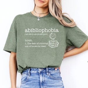 May include: Green t-shirt with the word "abibliophobia" defined as "the fear of running out of books to read".
