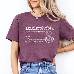 May include: A purple t-shirt with the word "abibliophobia" defined as "the fear of running out of books to read". The definition is accompanied by an illustration of a globe and a stack of books.