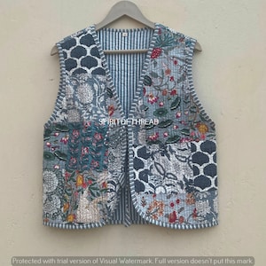 Könnte beinhalten: Eine blaue gesteppte Weste mit Patchwork-Design mit floralen und geometrischen Mustern. Die Weste hat einen V-Ausschnitt und eine gestreifte Rückseite.