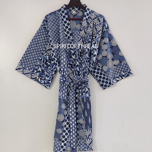 May include: A blue and white patterned robe with a matching belt. The robe features various geometric and floral designs in shades of blue. The text "SPIRIT OF THREAD" is visible on the robe.