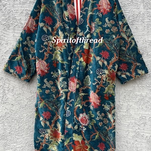 Pode incluir: Um quimono de veludo azul-petr&oacute;leo com um padr&atilde;o floral em vermelho, verde e creme. O quimono tem mangas compridas e um forro listrado vermelho e branco. O texto "Spiritofthread" &eacute; vis&iacute;vel.