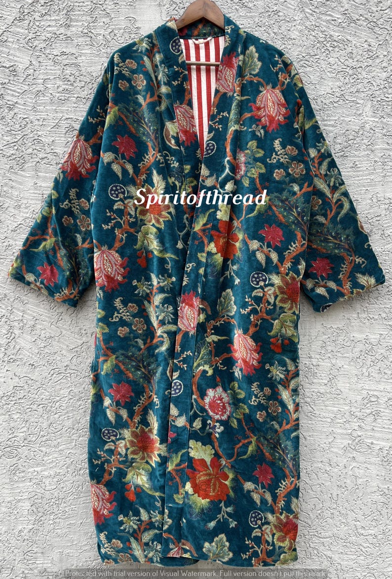 Pode incluir: Um quimono de veludo azul-petr&oacute;leo com um padr&atilde;o floral em vermelho, verde e creme. O quimono tem mangas compridas e um forro listrado vermelho e branco. O texto "Spiritofthread" &eacute; vis&iacute;vel.