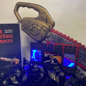 Super Deluxe Edition Texas Chain Saw Massacre VHS Lamp with large Chainsaw and gore. Horror film gift for horror film lovers & movie buffs