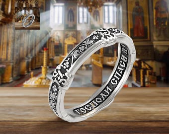 May include: A silver ring with an inscription in Russian that reads "Господи спаси" which translates to "Lord save". The ring is decorated with intricate floral designs.