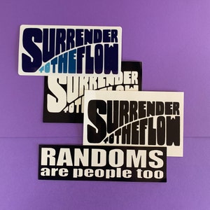 May include: Four rectangular stickers with white backgrounds and black or blue text. The top sticker reads "SURRENDER TO THE FLOW" in a bold font. The second sticker reads the same. The third sticker reads "SURRENDER TO THE FLOW" in black and white. The bottom sticker reads "RANDOMS are people too".