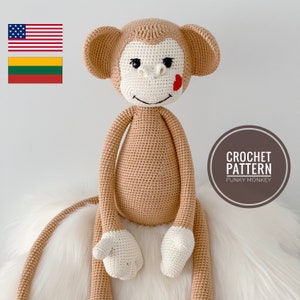 Może przedstawiać: Wzór na szydełku na zabawkę amigurumi funky małpę. Małpa jest beżowa z białą twarzą i czerwonym sercem na policzku. Wzór jest dostępny do pobrania.