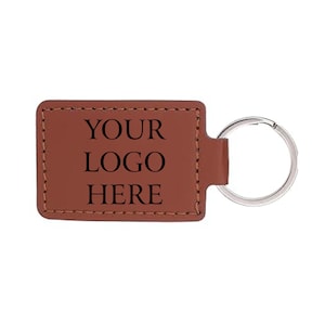 May include: A brown leather rectangular keychain with the text "YOUR LOGO HERE" in black. The keychain has a silver metal ring attached for keys.