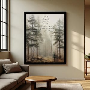 May include: A framed art print featuring a misty forest scene with tall trees. The artwork includes the quote "Of all the paths you take in life make sure a few of them are dirt - John Muir" in elegant script. The frame is black.
