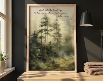 May include: A framed art print featuring a misty forest scene with tall evergreen trees. The artwork includes the quote "And into the forest I go to lose my mind and find my soul - John Muir" in black script. The frame is light-colored wood.
