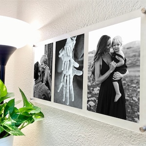 May include: A black and white photo collage featuring three images. The first image shows a man and a child looking at each other. The second image shows a close-up of several hands stacked on top of each other. The third image shows a woman holding a child in her arms.