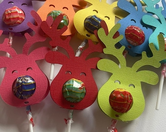 Könnte beinhalten: Ein Set aus bunten, rentierförmigen Papier-Lollihaltern mit Lollies, die in die Nase gesteckt werden. Die Rentiere sind aus strukturiertem Papier in den Farben Rot, Orange, Gelb, Grün und Blau.