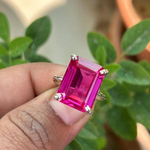 Puede incluir: Un anillo de plata con una piedra preciosa rosa de talla esmeralda.