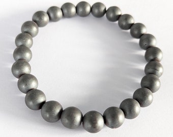 May include: A gray beaded bracelet made of round, smooth stones.