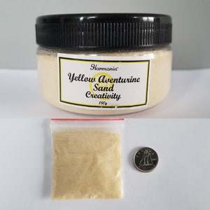 May include: A glass jar filled with yellow aventurine sand labelled "Harmonia Yellow Aventurine Sand Creativity 180g". A small plastic bag with a zip closure contains a sample of the sand. A Canadian 10-cent coin is included for scale.