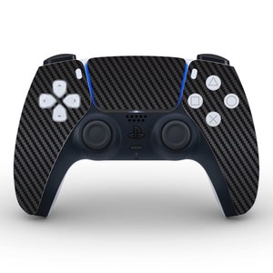 May include: A black and white PlayStation 5 DualSense wireless controller with a carbon fibre design. The controller has a black and white colour scheme and features a PlayStation logo on the front.