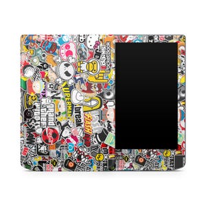 May include: A black e-reader case adorned with a vibrant assortment of stickers. The stickers display cartoon characters, logos, and text such as "Grand Theft Auto", "Superman", and "Flash". The e-reader has a black screen.