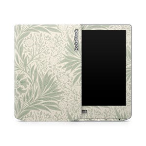 Könnte beinhalten: Ein E-Reader mit einer floral gemusterten Hülle in Creme und Salbeigrün. Die Hülle zeigt ein sich wiederholendes Design aus stilisierten Blumen und Blättern. Der Bildschirm des E-Readers ist schwarz, und der Markenname "PocketBook" ist auf der Hülle aufgedruckt.